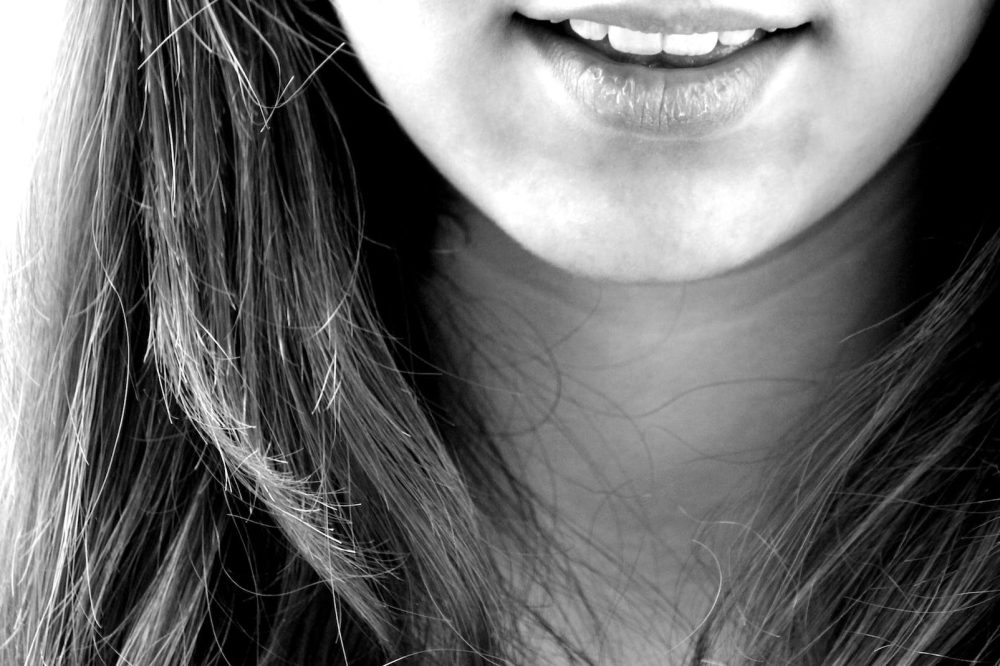 woman smiling in grayscale photography
