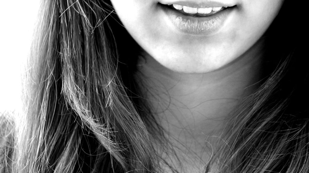 woman smiling in grayscale photography